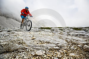 View of cyclist riding mountain bike on trail in Dolomites,Tre C