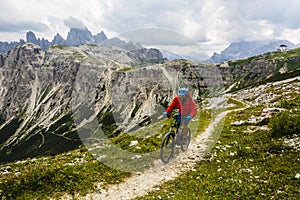 View of cyclist riding mountain bike on trail in Dolomites,Tre C