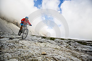 View of cyclist riding mountain bike on trail in Dolomites,Tre C