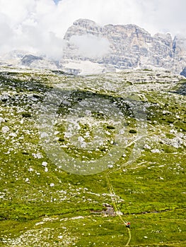 View of cyclist riding mountain bike on trail in Dolomites,Tre C