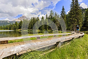 View of cyclist riding mountain bike on trail in Dolomites,Tre C