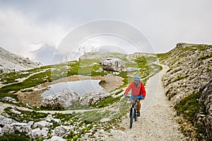 View of cyclist riding mountain bike on trail in Dolomites,Tre C