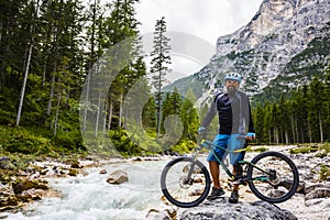 View of cyclist riding mountain bike on trail in Dolomites,Tre C