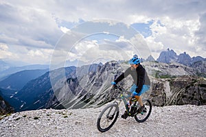 View of cyclist riding mountain bike on trail in Dolomites,Tre C