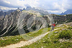 View of cyclist riding mountain bike on trail in Dolomites,Tre C