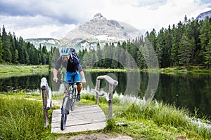 View of cyclist riding mountain bike on trail in Dolomites,Tre C