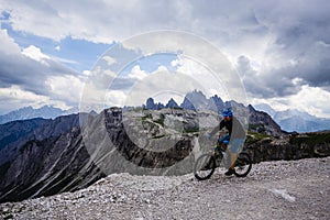 View of cyclist riding mountain bike on trail in Dolomites,Tre C