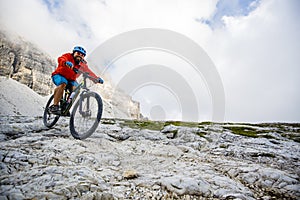 View of cyclist riding mountain bike on trail in Dolomites,Tre C