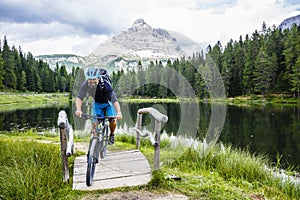 View of cyclist riding mountain bike on trail in Dolomites,Tre C photo