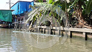 View of Damnoen Saduak village from speedboat running on a canal