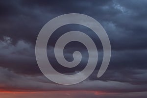 view on dark dramatic thunderstorm clouds at sunset