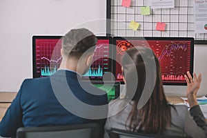 View of data analysts working on strategy of security with graphs on computer monitors