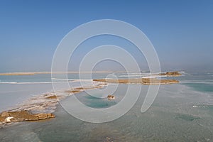 View of Dead Sea coastline with it`s beautiful sand and salt in the middle of the water. Aerial shot captured from the