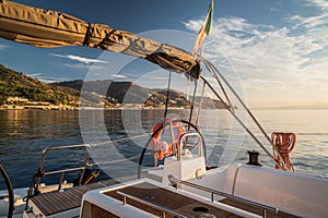 View from deck of sailing boat with rudder and italian flag