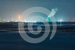 View of Delfzijl city toward to Eemshaven with industrial area on the coast at night at low tide in Netherlands