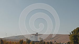 View of a deserted hill with windmills on top.