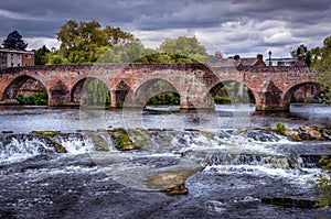 View of Devorgilla Bridge with rocks and streams.