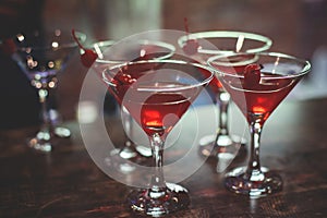 View of different coloured alcohol beverage cocktail drinks setting on bar counter in the night club party, tequila, glasses with