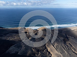 View on difficult to access golden sandy Cofete beach hidden behind mountain range on Fuerteventura, Canary islands, Spain