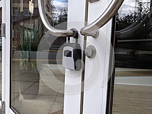 View of a digital padlock on glass office building doors