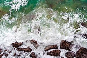 View from directly above on sea wave and rocks