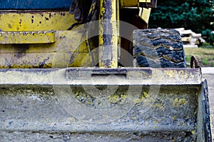 view of the dirty bucket of a yellow scratched construction bulldozer. construction work concept