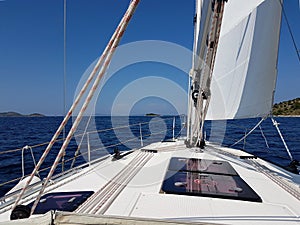 View into the distance from the cockpit of a yacht sailing past the green islands against a blue clear sky. Active rest and fascin