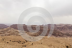 View from distance from high hill to famous gorge in which it is located thr Nabatean Kingdom of Petra in the Wadi Musa city in