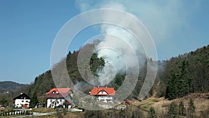 View from distance, smoke in forest near houses