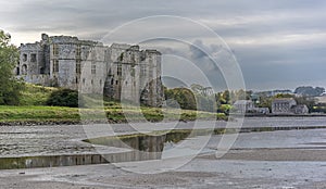 A view down the Carew estuary, past the ruins of Carew Castle towards the Tidal Mill in Pembrokeshire, UK