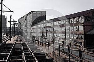 View down railroad tracks alongside abandoned industrial buildings