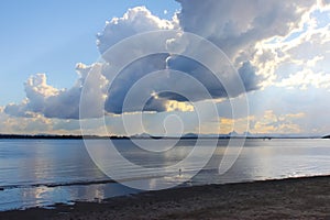 View of dramatic clouds and early sunset looking from Bribie Island over the Pumicestone Passage to the Glass Mountains in Queensl