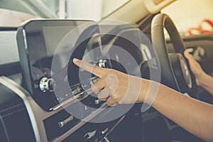 View of driver holding steering wheel and testing car operating system using front touchscreen display of car