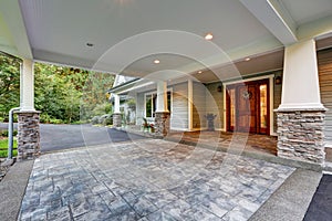 View of driveway with an all weather covered entry