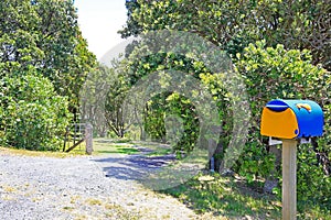 View of driveway, open gate and a post box