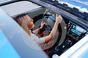 View of a driving woman through sunroof