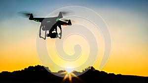 View of drone flying with digital camera over a field with sunset