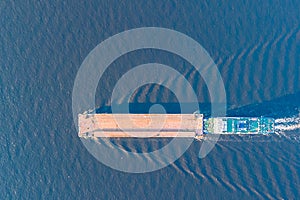 View from a drone of a river tugboat moving cargo barge to navigate the Volga river.