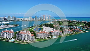 View from drone on spectacular Fisher Island with stunning high-rise residential buildings along oceanfront and private