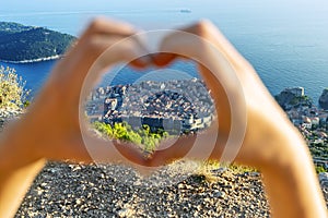 View of Dubrovnik through women`s heart-shaped hands. Croatia, Europe