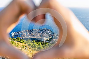 View of Dubrovnik through women`s heart-shaped hands. Croatia, Europe