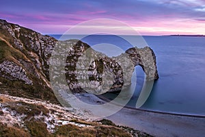 View of Durdle Door in United Kingdom at Sunset.