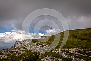 View from the edge of Rax plateau, with green, grassy meadow and blue cloudy sky