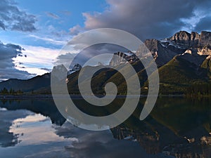 View of Ehagay Nakoda massif near Canmore, Alberta, Canada in the Rocky Mountains after sunrise mirrored in water.