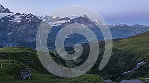 View on the Eiger Nordwand and other famous Swiss Alpine mountains during sunrise on a summer morning