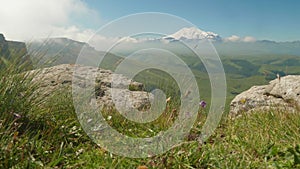 View of Elbrus covered with snow from plateau Bermamyth. Sunny summe afternoon and clouds in the sky