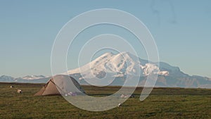 View of Elbrus from plateau Bermamyth in early morning. Amazing view of Russain nature. Touristic tent is at the left of
