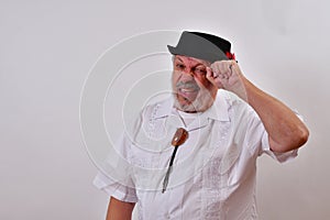 View of an elderly man in a hat scratching his head trying to remember on a white background