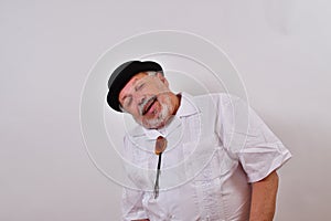 View of an elderly man smiling and enjoying the view wearing a shirt and a hat on white