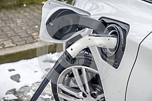 View of an Electric Car Charging and in the background a partial view of a car